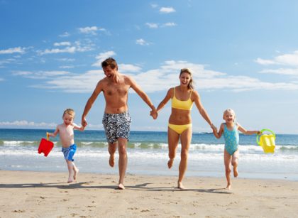 Family with kids playing on the beach during a Costa Rica family vacation